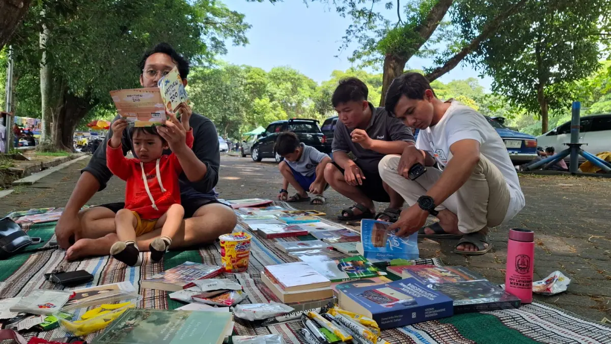 LITERASI MENINGKAT: Warga membaca buku koleksi Komunitas Kanjuruhan Membaca yang berada di area Stadion Kanjuruhan beberapa waktu lalu. (Komunitas Kanjuruhan Membaca for Radar Malang)
