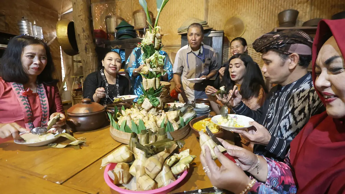 LESTARIKAN BUDAYA: Warga di Kampung Budaya Polowijen makan
bersama menu ketupat sayur, kemarin.