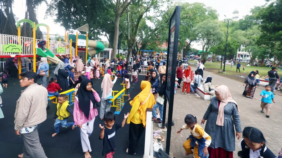 BERJUBEL: Wisatawan yang didominasi anak-anak bermain di playground Alun-Alun Merdeka kemarin (29/3). Jumlah kunjungan meningkat drastis dibanding hari biasa.