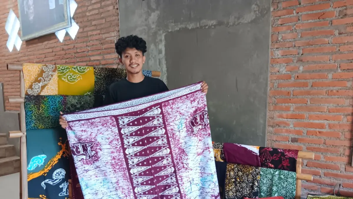 DIBUAT TERBATAS: Jahfal Alafa Jirfasi memamerkan salah satu batik cungkup yang diproduksi di rumahnya kemarin siang. (Indah Mei Yunita/Radar Malang)