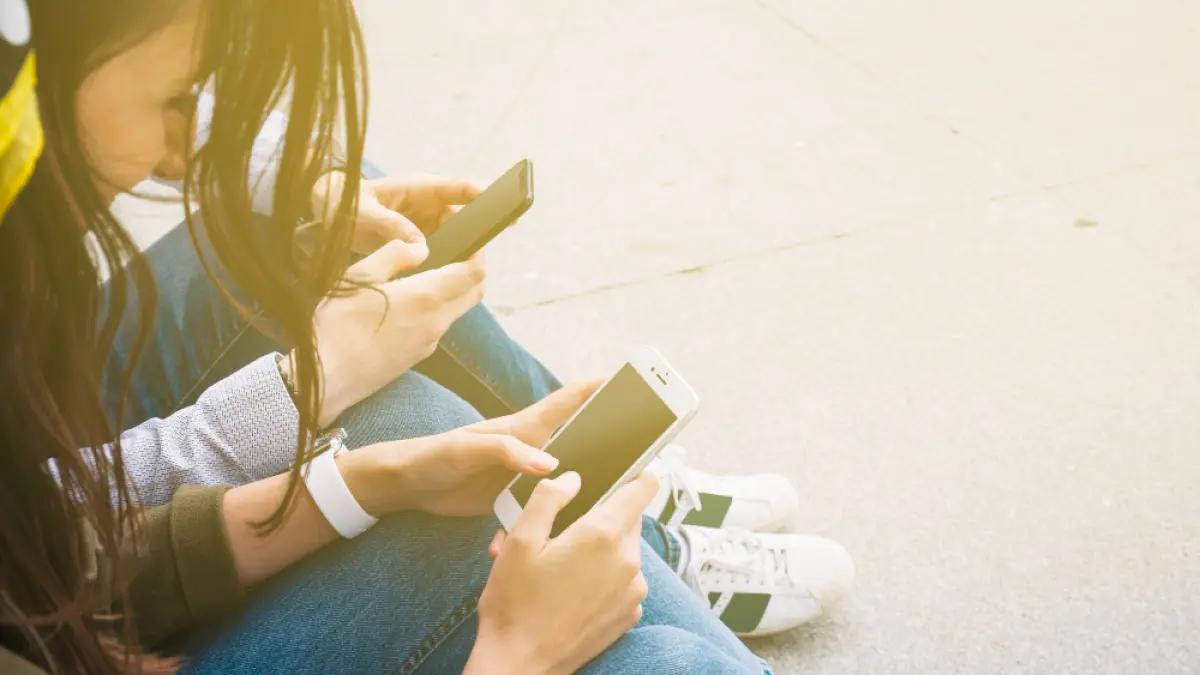 Potret dua remaja bermain smartphone. (Freepik).