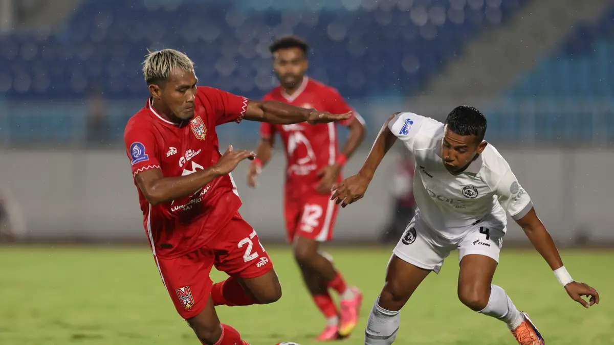 Bek kiri Arema FC Leo Guntara (kanan) berbebut bola dengan pemain Malut United Safrudin Tahar di Stadion Kanjuruhan, Jumat (3/4). (Darmono/Radar Malang)