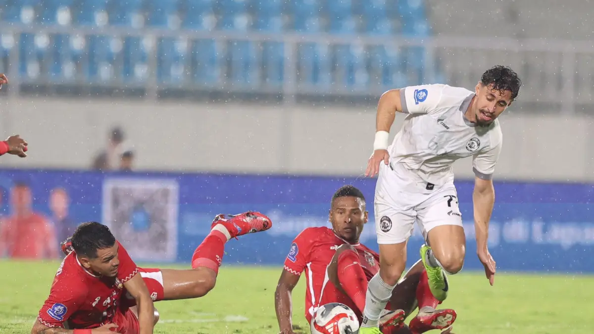 Pemain Aremaa FC Gustavo Franca berhasil lepas dari kawalan dua pemain Malut United. (Darmono/Radar Malang)