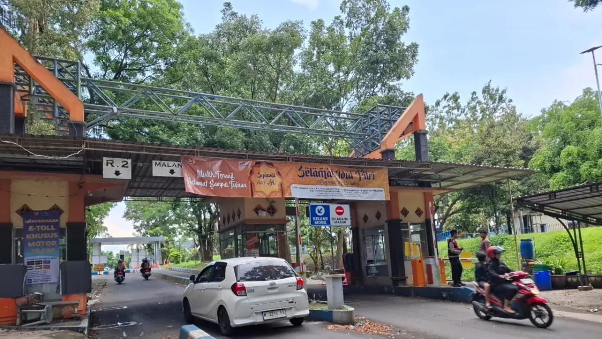BELUM PULIH 100 PERSEN: Sejumlah kendaraan melintasi portal Bendungan Lahor kemarin siang. Tampak ada sejumlah polisi masih berjaga di sana. (Biyan Mudzaky Hanindito/Radar Malang)
