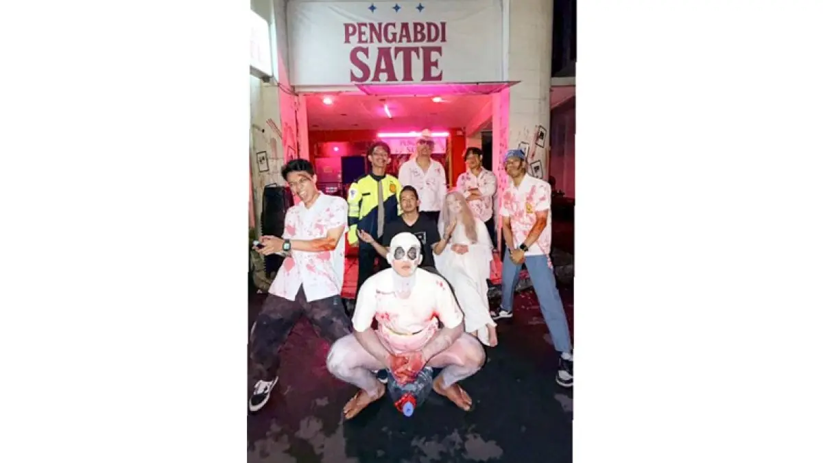 BERUBAH PERAN: Pramusaji Pengabdi Sate berpakaian ala setan kemarin. Meski terkesan menakutkan, pengunjung selalu ramai setiap hari.
