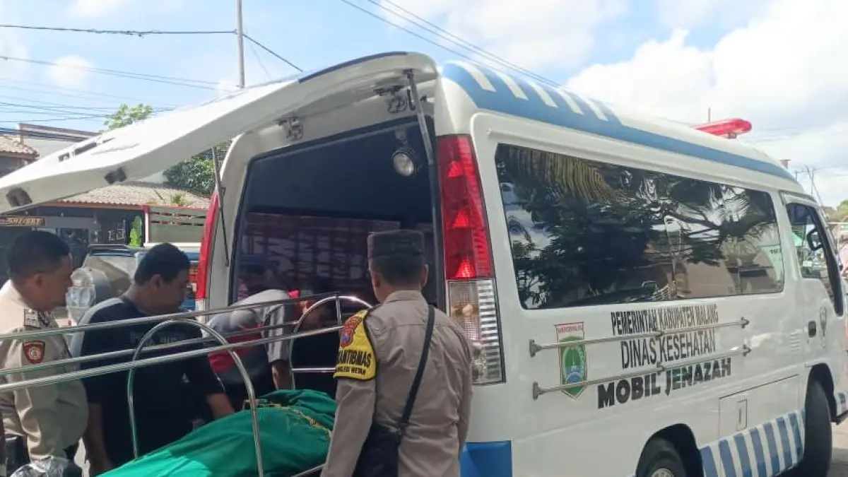EVAKUASI: Petugas memasukkan korban ke mobil jenazah.