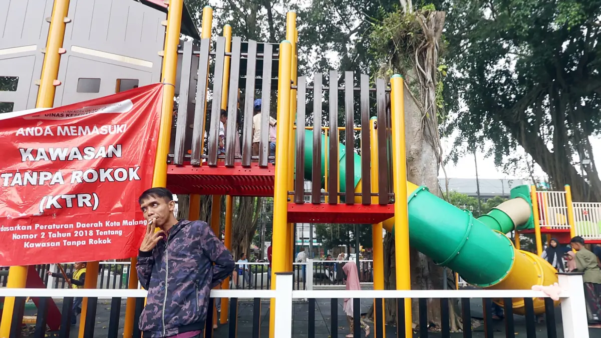 FOTO DARMONO
PERLU KESADARAN: Seorang pria merokok di area Playground Alun-Alun Merdeka kemarin (5/4). Area ini merupakan kawasan bebas asap rokok.