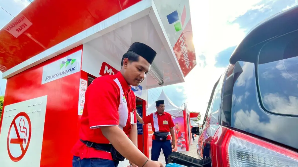 SEPENUH HATI: Petugas SPBU Pertamina melayani konsumen.