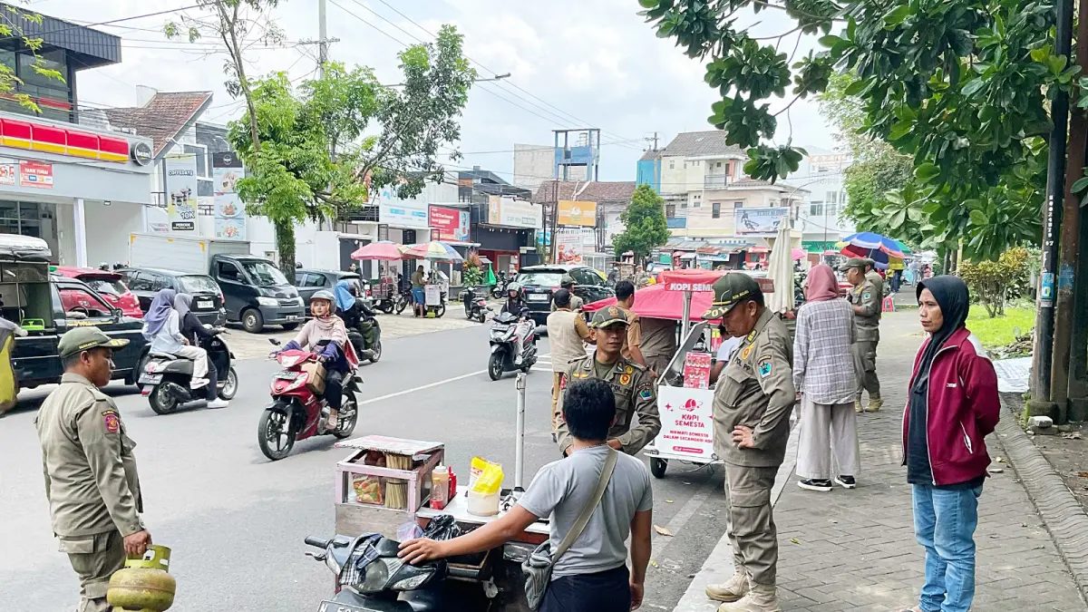 TITIK KETIGA: Petugas Satpol PP Kota Malang menertibkan sejumlah PKL yang mangkal di Jalan Surabaya, kemarin. (ANDIKA SATRIA PERDANA / RADAR MALANG)