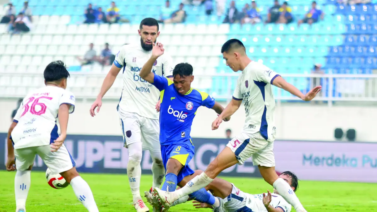 GANTI VENUE: Gelandang Arema FC Arkhan Fikri (tengah) berusaha lepas dari penjagaan pemain Persita Tangerang dalam BRI Super League pekan pertama di Stadion Kanjuruhan. (Foto: Darmono)
