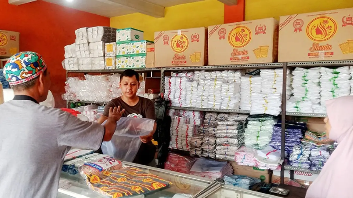 BANYAK BATALKAN PESANAN: Seorang penjual plastik di Jalan Muharto, Kota Malang, tengah melayani pembeli kemarin. Harga plastik di tingkat grosir meningkat dua kali lipat. (Foto: Andika Satria Perdana/Radar Malang)