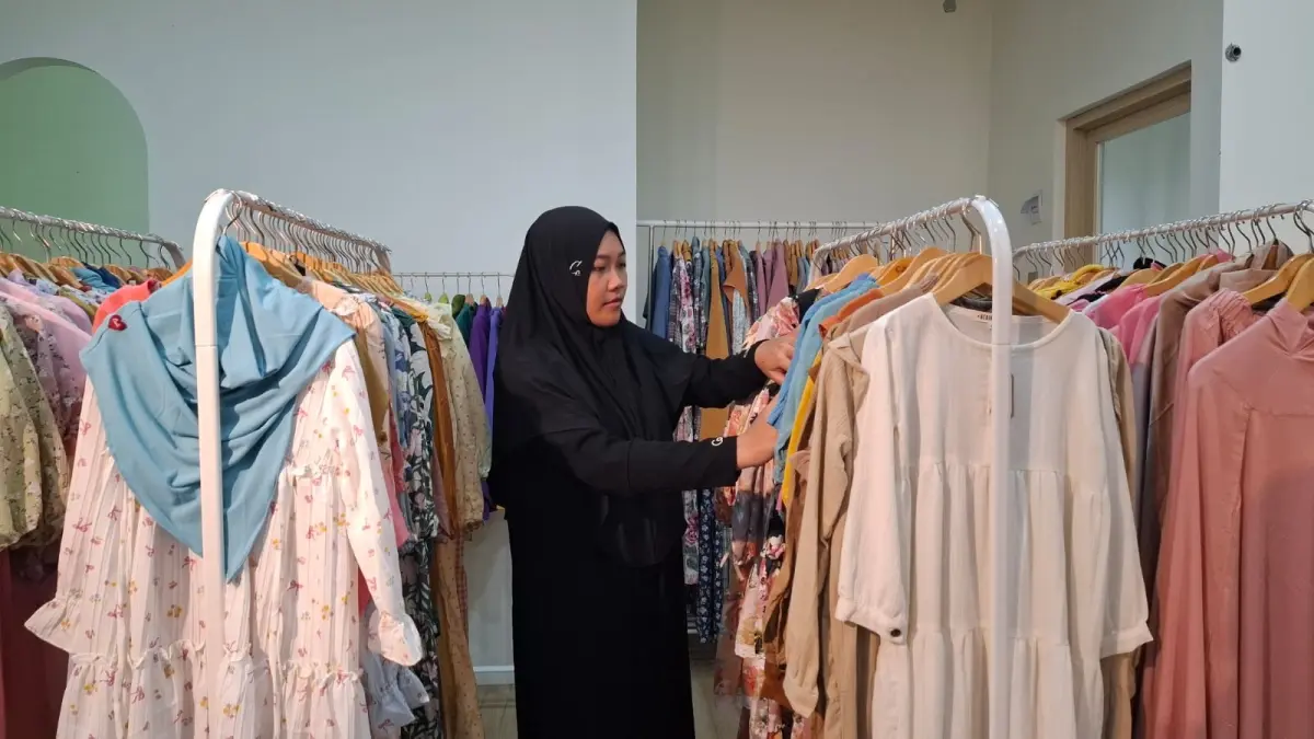 PRODUK LOKAL: Seorang pengunjung memilih pakaian gamis anak di Casila Indonesia, Desa Wonorejo, Kecamatan Poncokusumo kemarin.

