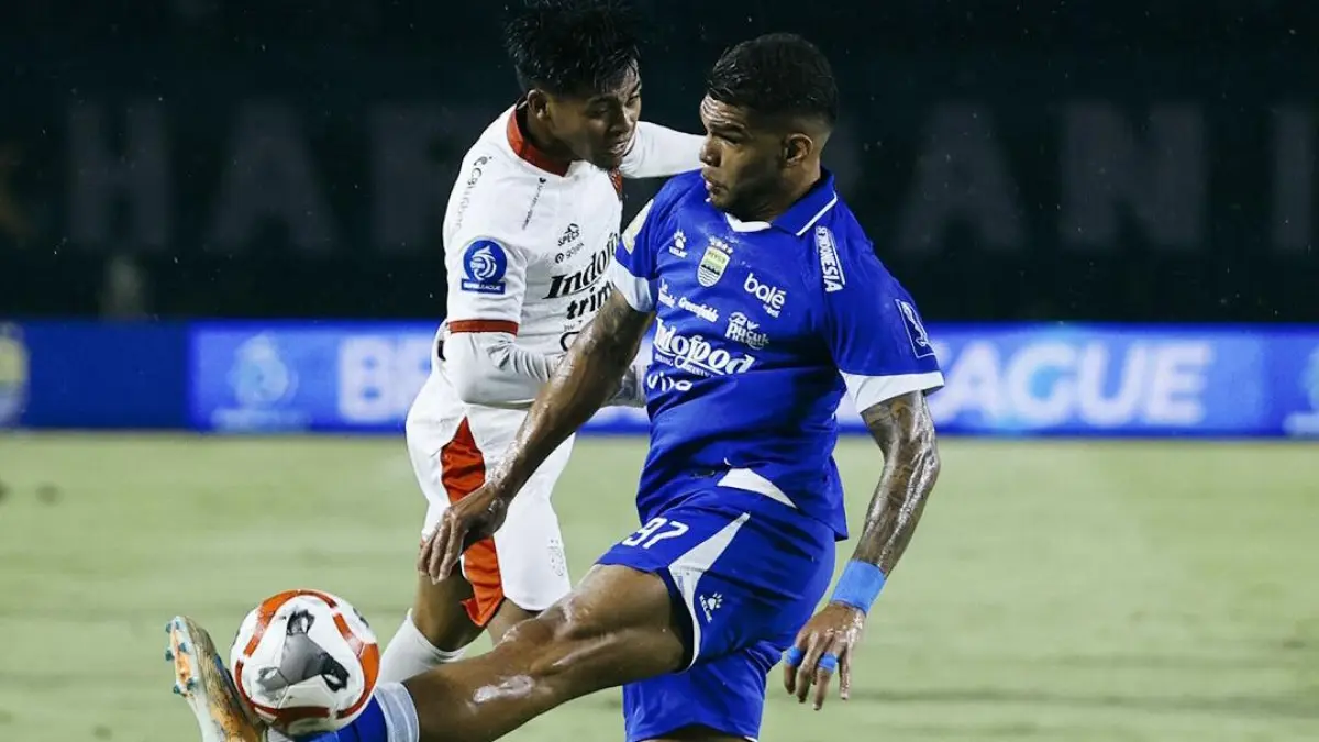 Pemain Persib Bandung (biru) berusaha mengontrol bola di bawah tekanan pemain Bali United (putih) dalam laga pekan ke-27 BRI Super League di Stadion Gelora Bandung Lautan Api, Minggu (12/4). (Instagram @persib)