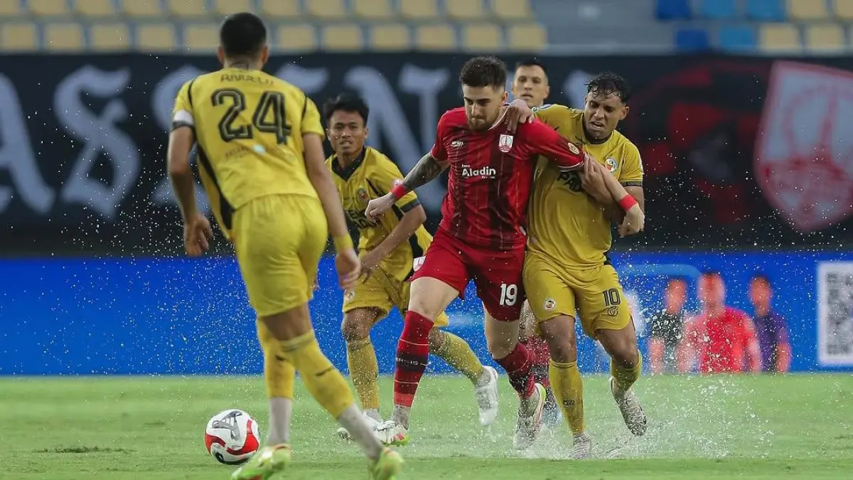 Pemain Persis Solo (merah) berusaha melewati kawalan ketat pemain Semen Padang FC (kuning) dalam laga pekan ke-27 BRI Super League di Stadion Manahan, Solo, Minggu (12/4). (Instagram @persisofficial)