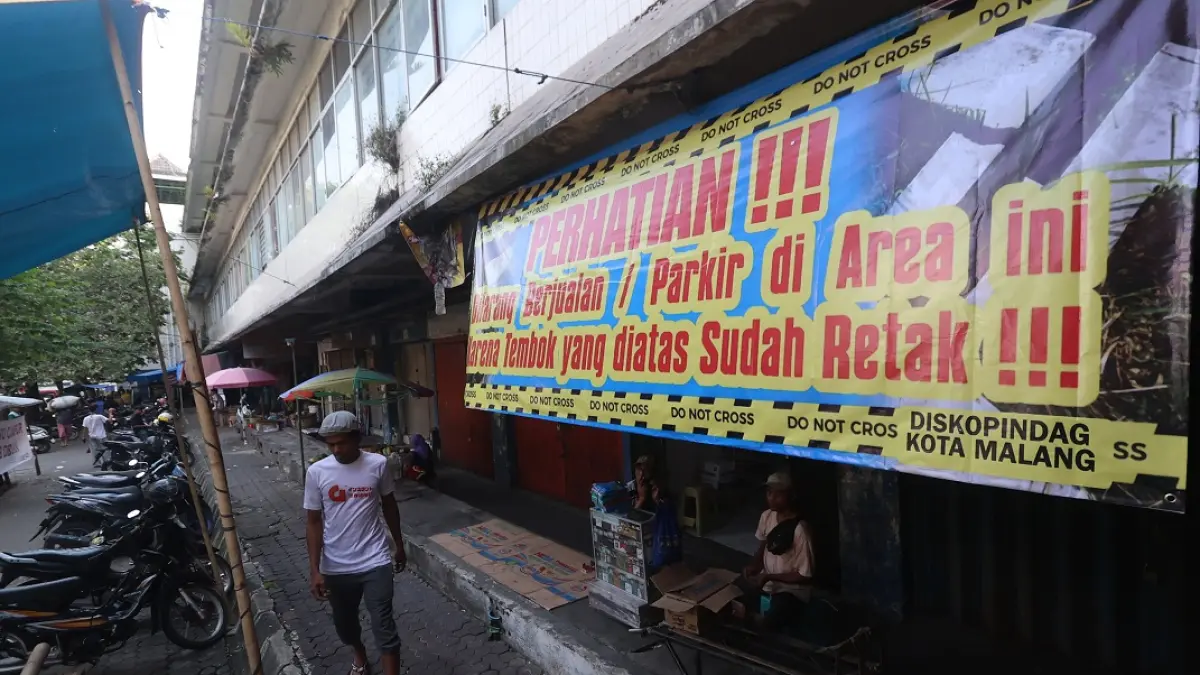 PENCEGAHAN: Banner berisi imbauan dipasang Pemkot Malang di sisi bangunan Pasar Besar Malang di Jalan Kopral Usman. (Darmono / Radar Malang)