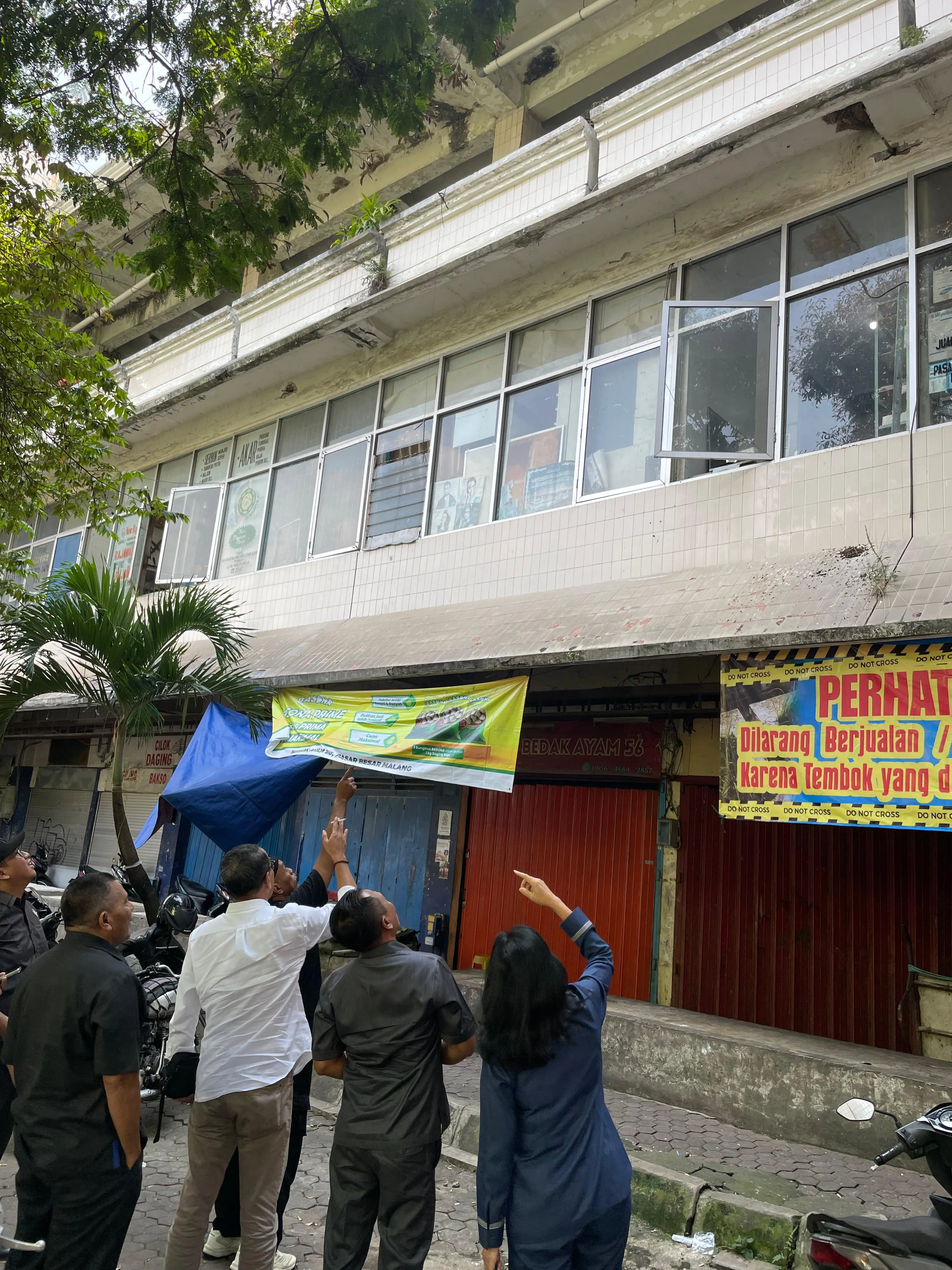 Anggota Komisi B DPRD Kota Malang meninjau retakan bangunan di lantai 3 Pasar Besar Malang dari bawah. (Andika Satria/Radar Malang)