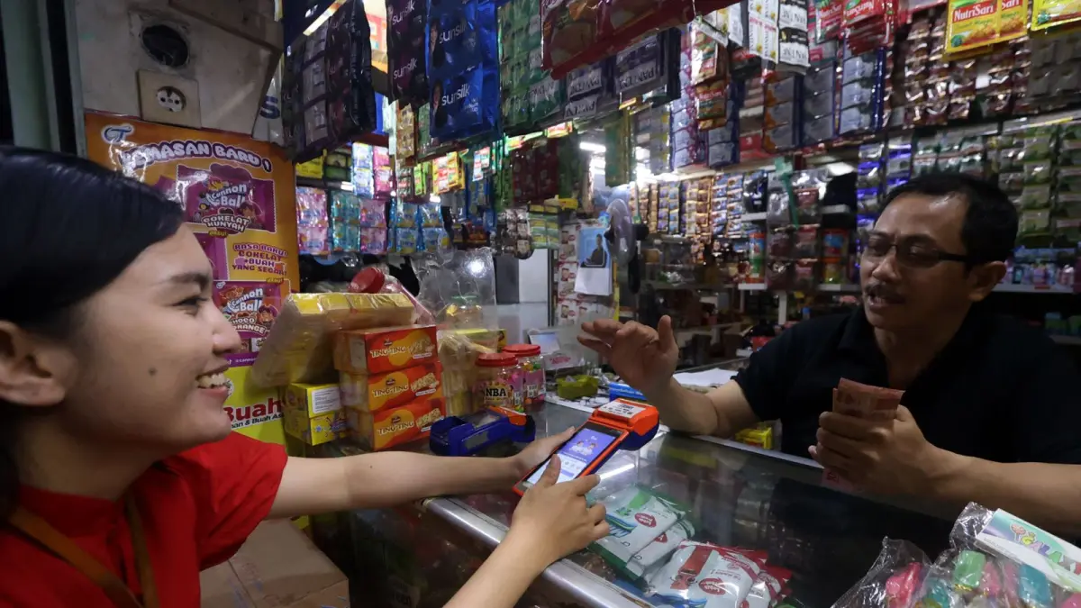 LAYANAN PICK UP BANK: Salah satu pedagang di Pasar Besar Kota Malang memanfaatkan layanan setor tunai kepada petugas Bank BRI, kemarin. (foto: Darmono) 