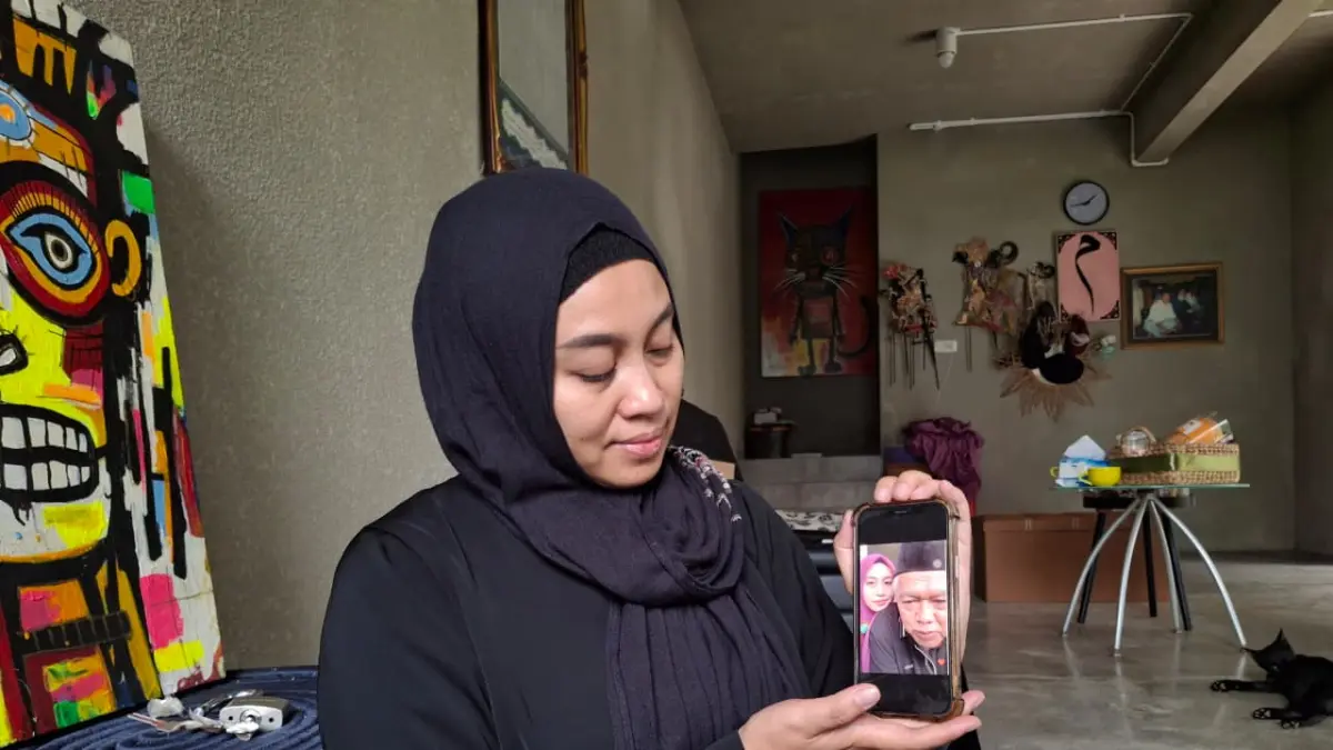 Rosyida Vignesvari atau Ines, istri mendiang Yai Mim menunjukkan foto dengan sang suami, Kamis (16/4). (Nabila Amelia/Radar Malang)