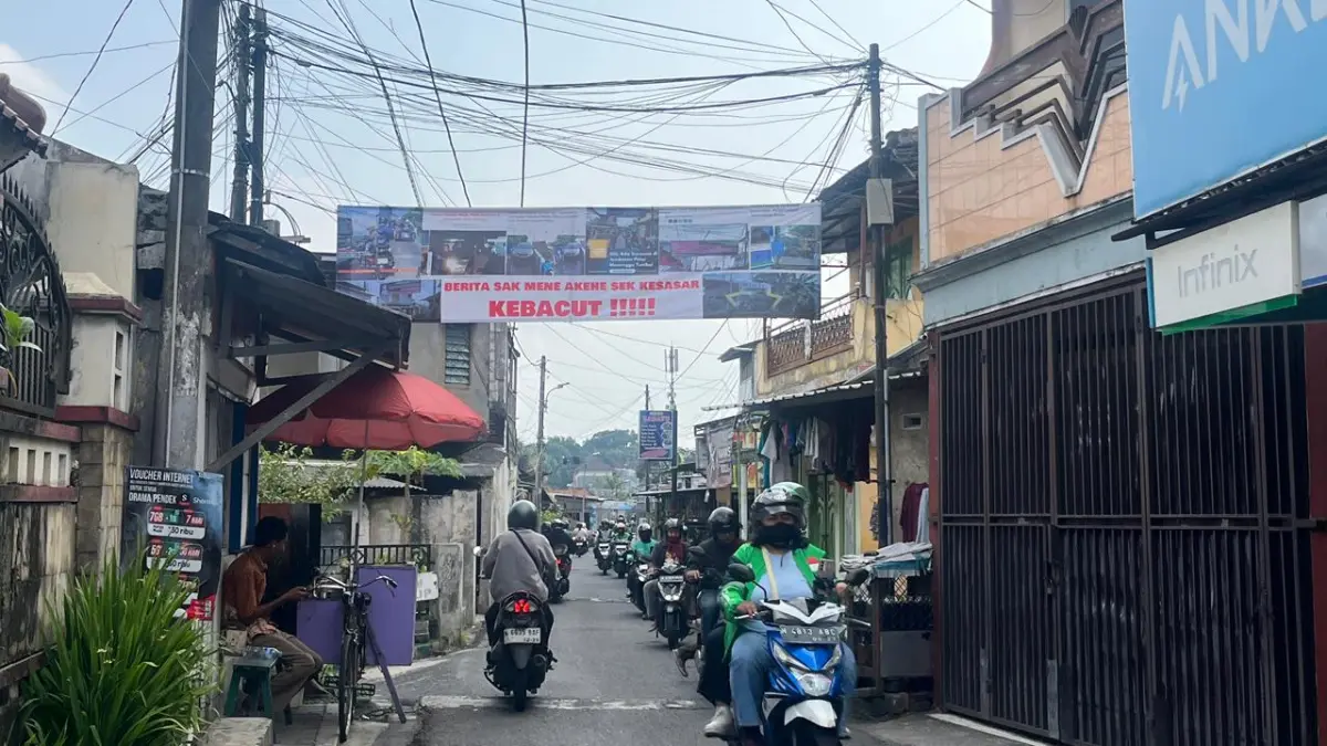 Banner peringatan dipasang warga dekat Jembatan Pelor. (Nahdiatul Affandiah/Radar Malang)