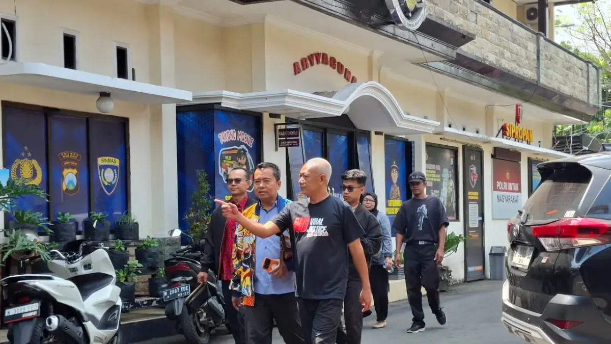 Pak Dur (kanan) berjalan menuju ruang pemeriksaan di Mapolres Malang, Jumat (17/4). (Biyan Mudzaky Hanindito/Radar Malang)