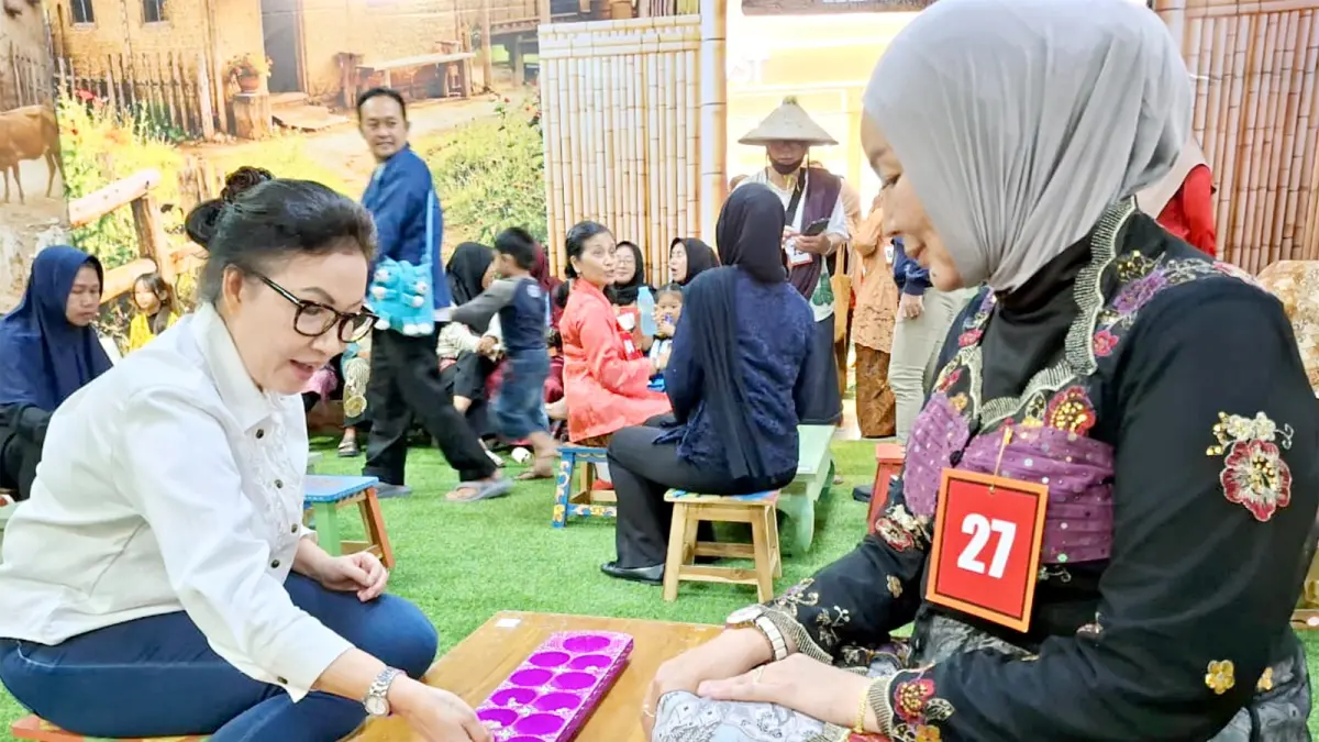 BABAK FINAL: Mall Director Matos Fifi Trisjanti (kiri) ikut mencoba permainan tradisional dakon, kemarin (18/4). (Nabila Amelia / Radar Malang)
