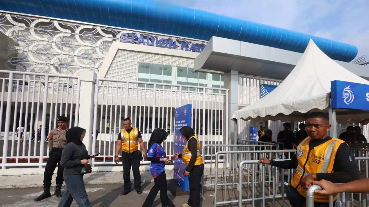 ENGGAN KECOLONGAN: Petugas keamanan laga Arema FC memeriksa barang bawaan suporter dan tiket sebelum mereka masuk ke ring dua Stadion Kanjuruhan. (foto: Darmono/Radar Malang)