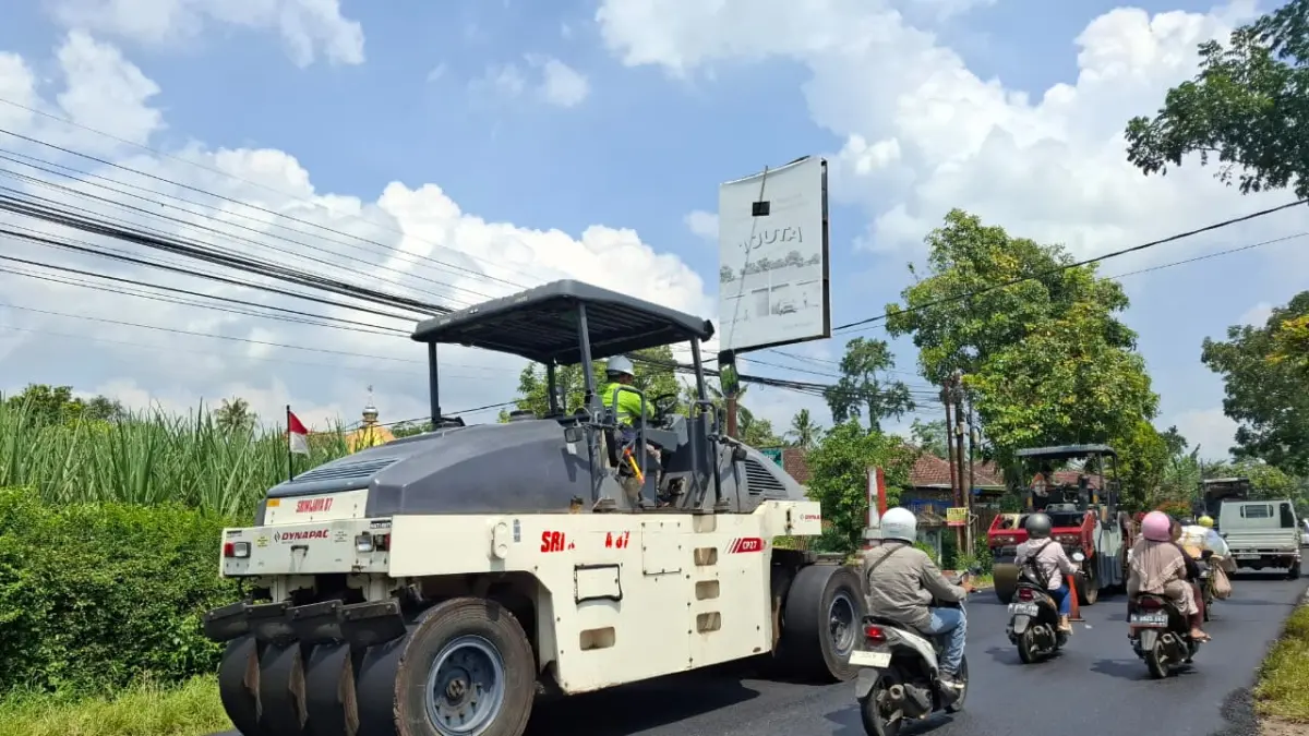 Petugas memadatkan aspal yang baru saja dikerjakan di ruas Jalan Kepanjen-Kendalpayak menggunakan tandem roller kemarin siang. (Biyan Mudzaky Hanindito/Radar Malang)