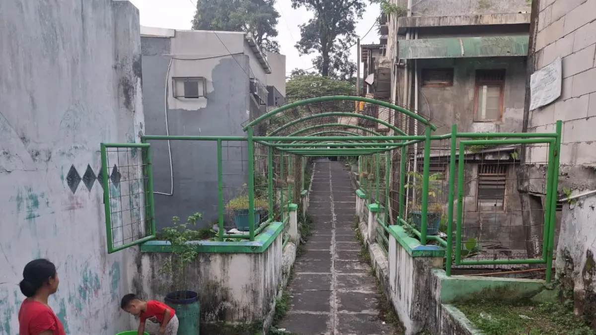 JADI PERHATIAN: Seorang anak didampingi orang tuanya akan melintas Jembatan Bareng di RT 6 RW 4 Kelurahan Bareng, Kecamatan Klojen, kemarin.(Foto: Nabila Amelia)