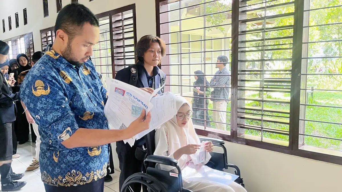 BERI PENDAMPINGAN: Peserta UTBK disabilitas menjalani pemeriksaan sebelum masuk ruang tes di Gedung PTIK lantai 1 UM, kemarin. (NAHDIATUL AFFANDIAH/RADAR MALANG)