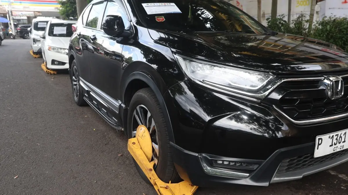 KENA TEGURAN: Mobil-mobil yang parkir sembarangan di samping RSUD dr Saiful Anwar (RSSA) Malang digembok petugas, kemarin (22/4). (DARMONO/RADAR MALANG)