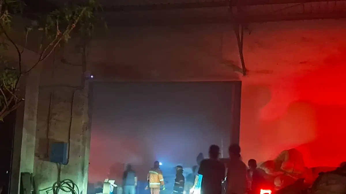 Perugas Damkar Kota Malang berusaha memadamkan api yang melalap gudang pabrik rokok di Jalan Mayjend, Sungkono, Kedungkandang, Jumat (24/4). (Nabila Amelia/Radar Malang)
