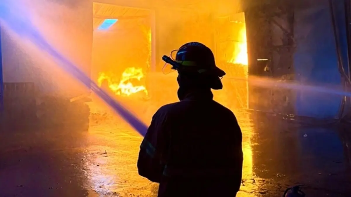 DISELIDIKI POLISI: Salah satu petugas berupaya memadamkan api yang membakar gudang di Jalan Mayjend Sungkono, Kelurahan Buring, Kecamatan Kedungkandang, Jumat sore (24/4). Foto bawah, proses pendinginan dilakukan sampai Jumat malam sekitar pukul 21.30. (DAMKAR KOTA MALANG FOR RADAR MALANG)