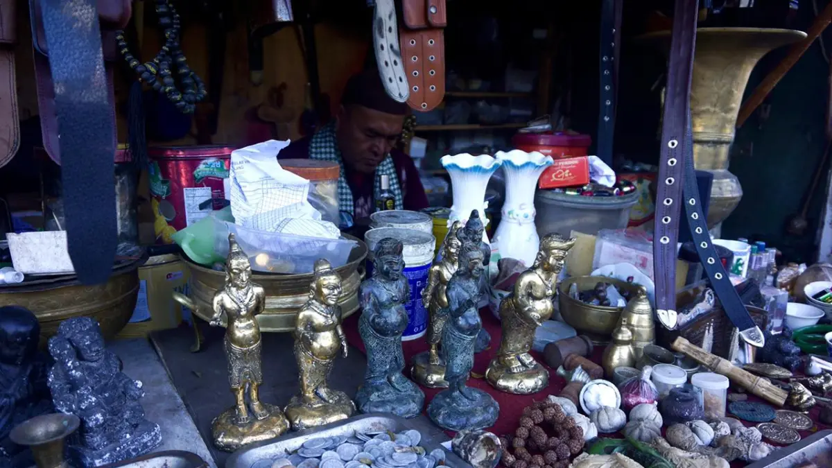 Koin kuno dan barang-barang antik tertata rapi di lapak Junlian kemarin pagi. (Rori Dinanda Bestari/Radar Malang)