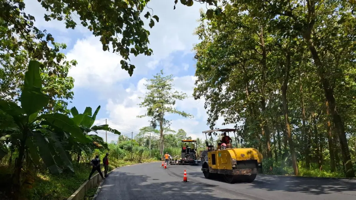 Pekerja melakukan pemadatan aspal di jalur Gondanglegi-Balekambang menggunakan tandem roller kemarin siang. (Biyan Mudzaky Hanindito/Radar Kanjuruhan)