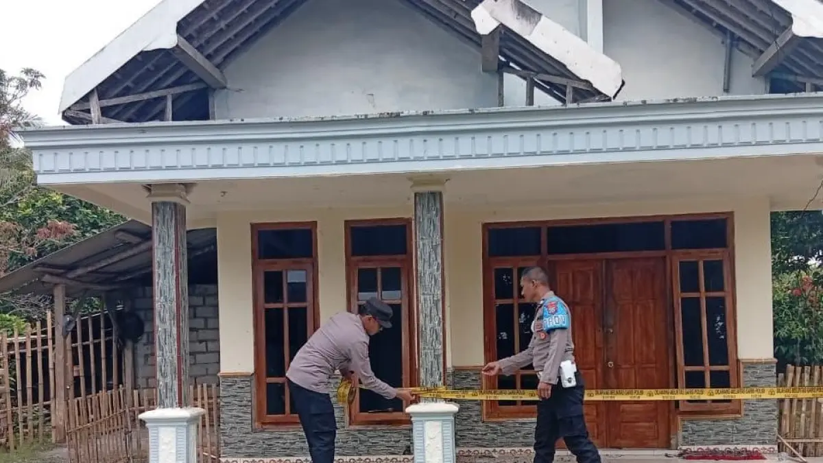 Polisi memasang police line di rumah warga Bantur yang dilempari bondet. (Istimewa)