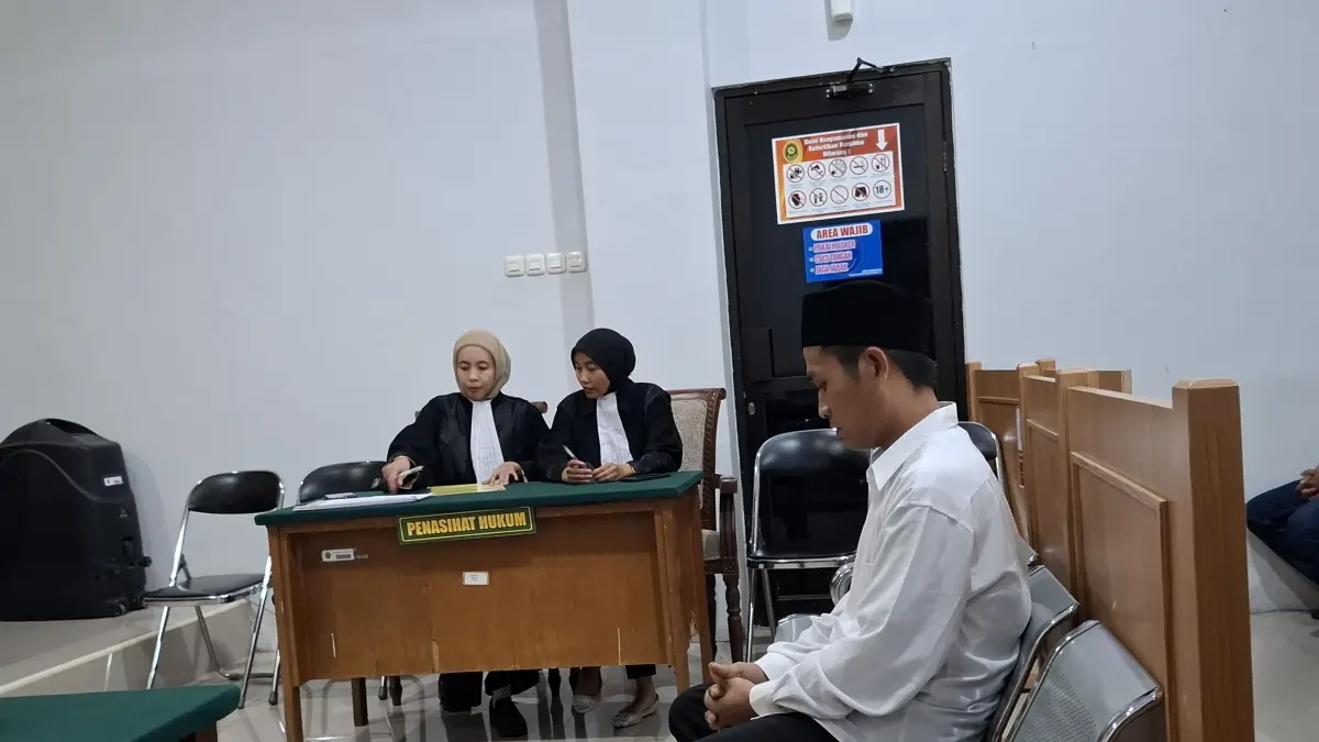 MENUNDUK: Terdakwa saat di persidangan.