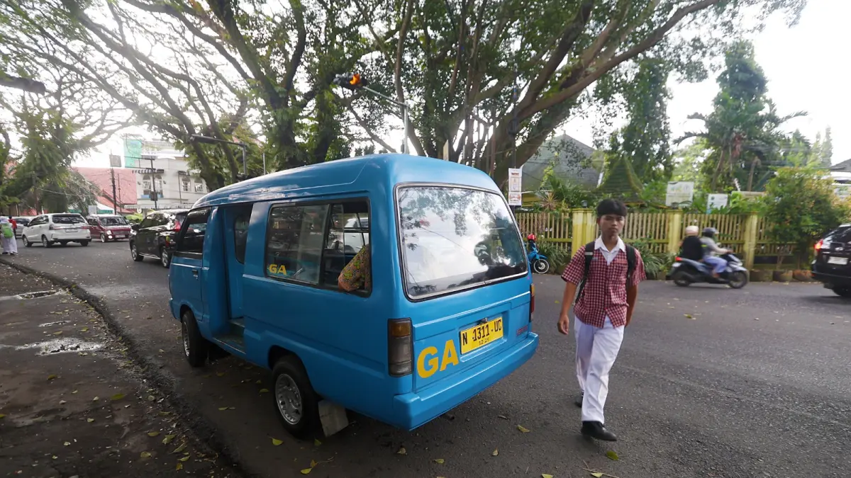 MOLOR DARI JADWAL: Salah satu angkot melintas di depan SMPN 5 Malang, kemarin. Pemkot Malang berjanji segera merealisasikan program angkot pelajar.