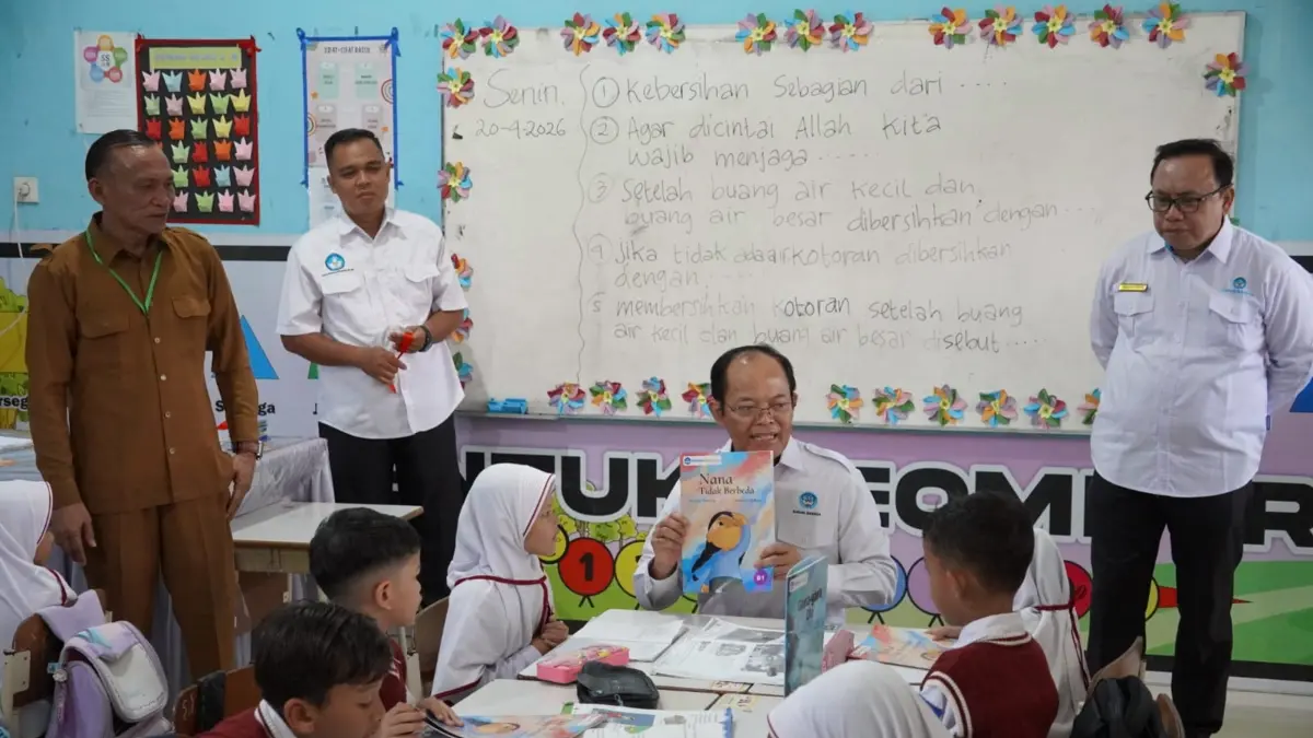 PERKUAT LITERASI: Kepala Badan Bahasa Hafidz Muksin (tengah), memberikan tambahan buku kepada murid di Aceh. (Dok. Kemendikdasmen)