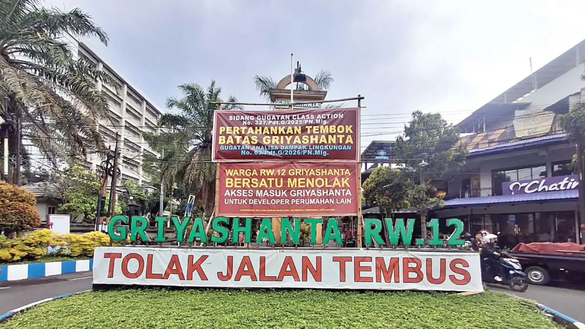 SIAPKAN LANGKAH LANJUTAN: Banner berisi penolakan proyek jalan tembus masih dipasang warga Perumahan Griyashanta. (NABILA AMELIA/RADAR MALANG)