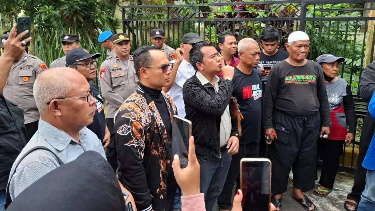 TERUS BERPOLEMIK: M. Sholeh (empat dari kanan) bersama Pak Dur (tiga dari kanan) keluar dari ruang penyidik Satreskim Polres Malang kemarin siang.