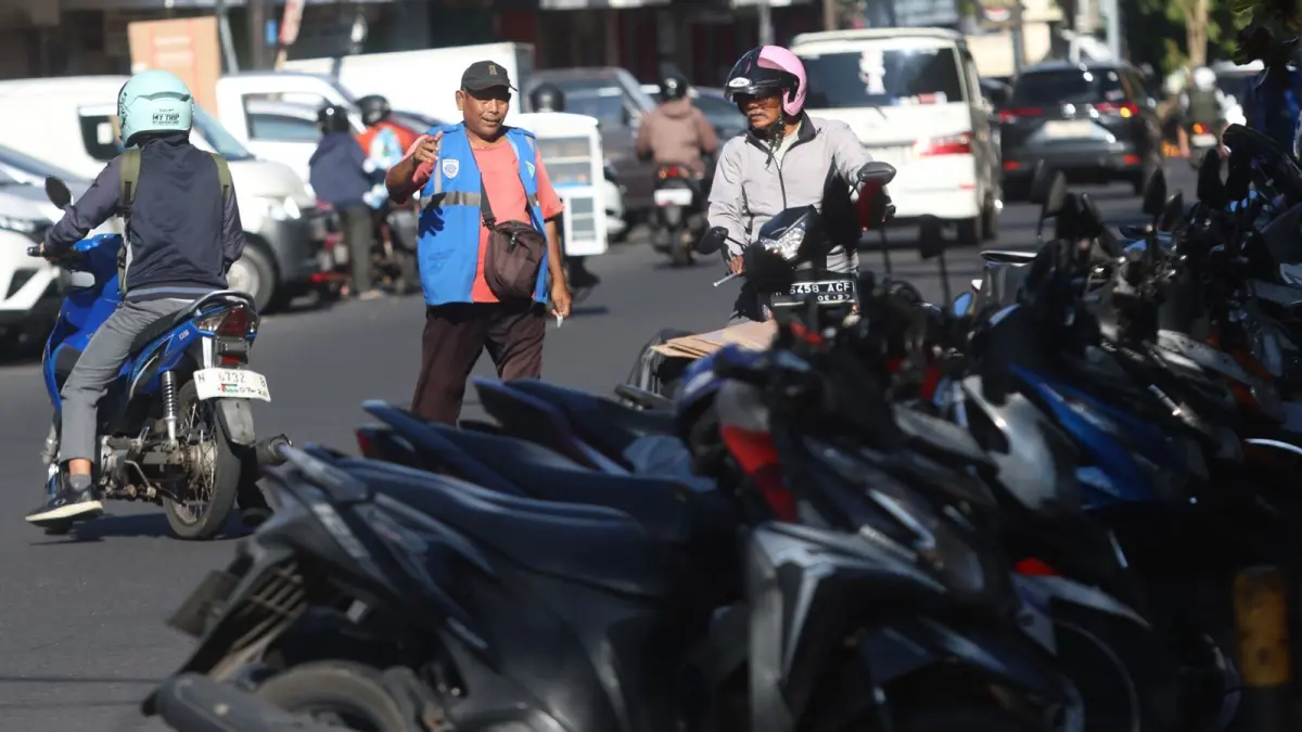 BELUM MAKSIMAL: Salah satu juru parkir di Jalan Pasar Besar memberi arahan kepada salah satu pengendara motor, kemarin (30/4).