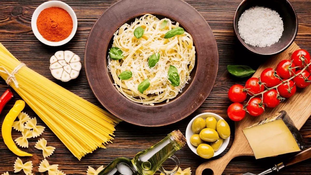 Komposisi makanan Italia yang meliputi pasta, tomat ceri, zaitun, keju, dan minyak zaitun. (Freepik / Google)