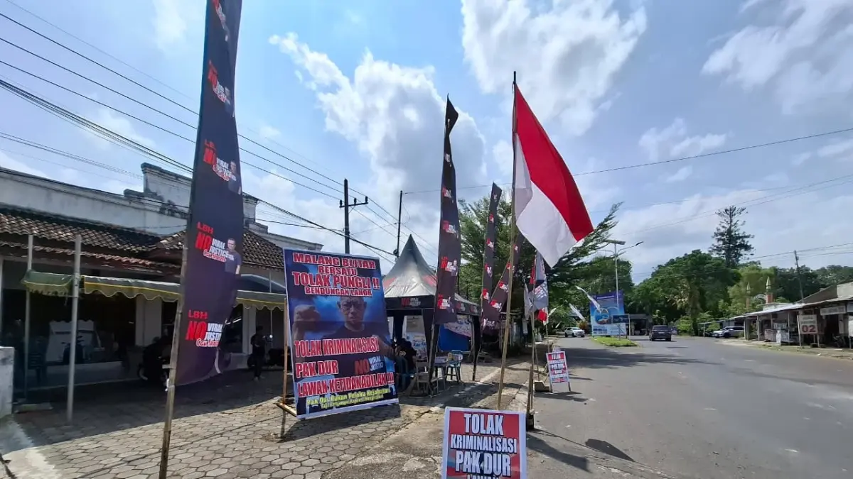 Banner untuk Hadi Wiyono alias Pak Dur terpasang di posko solidaritas, kemarin siang.(Biyan Mudzaky Hanindito/Radar Malang)