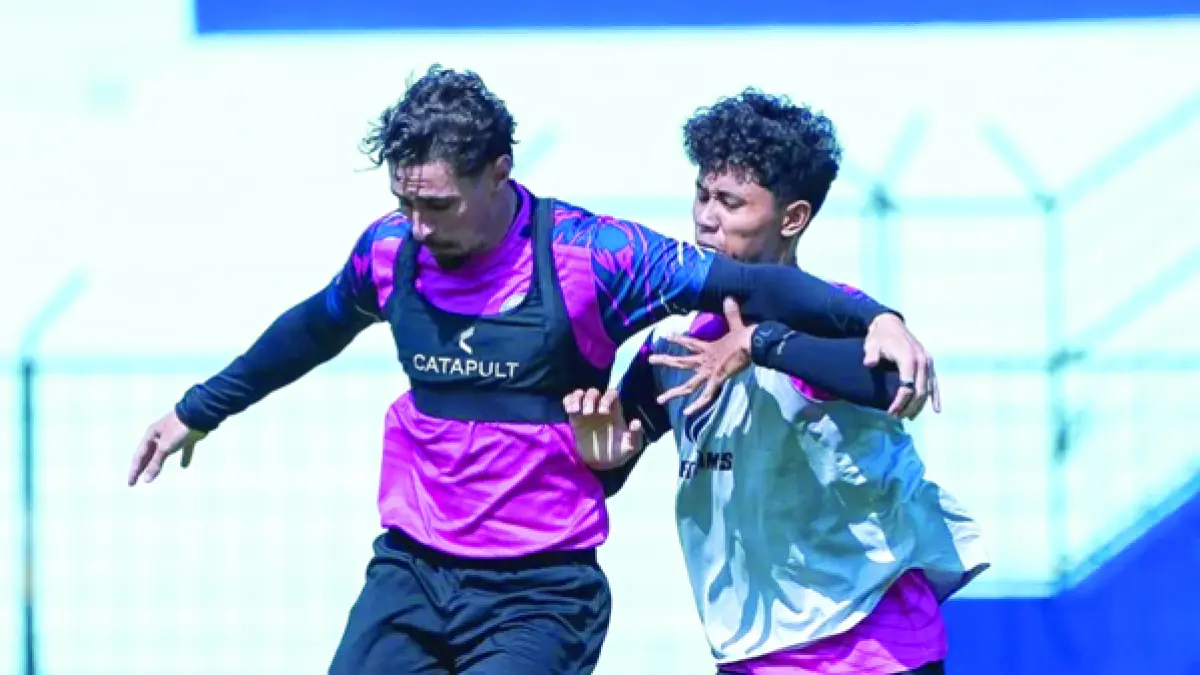TETAP TERMOTIVASI: Gustavo Franca (kiri) berebut bola dengan pemain muda Arema FC Dimas Aryaguna dalam sesi latihan di Stadion Gajayana, beberapa waktu lalu. (foto: MO Arema FC)