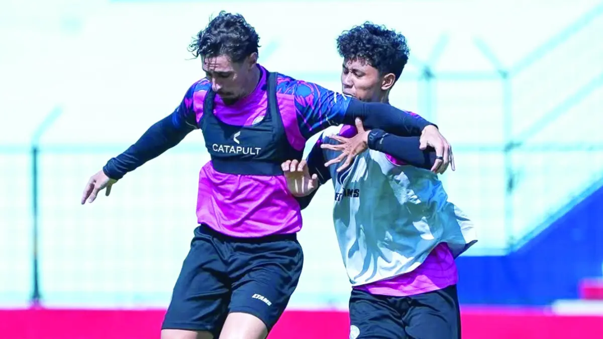 TETAP TERMOTIVASI: Gustavo Franca (kiri) berebut bola dengan pemain muda Arema FC Dimas Aryaguna dalam sesi latihan di Stadion Gajayana, beberapa waktu lalu. 