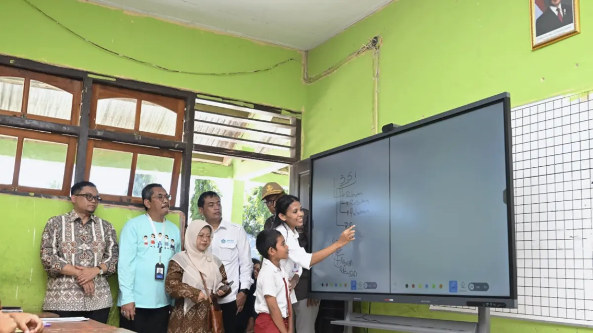 Guru sedang mempraktikkan penggunaan Interactive Flat Panel (IFP) kepada salah satu murid. (Dok. Kemendikdasmen)