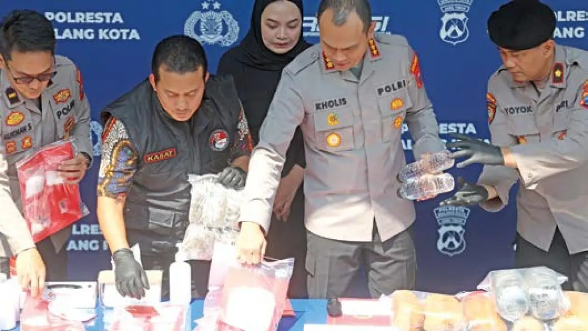 TUNJUKKAN BARANG BUKTI: Kapolresta Malang Kota Kombes Pol Putu Kholis Aryana (dua dari kanan) memegang miras ilegal dan narkoba yang berhasil diamankan Polresta Malang Kota pada periode April-Mei, kemarin. (foto: Darmono)