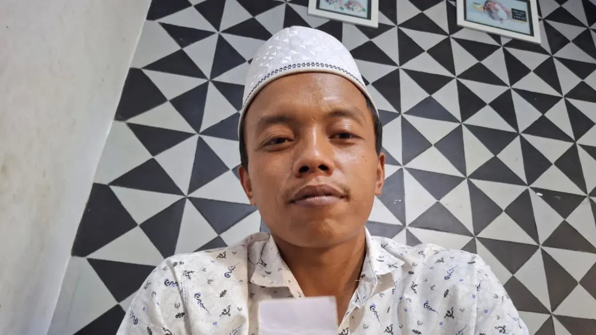 Anak kedua korban, Harianto, menunjukkan foto Mat Suhadi dengan ibunya. (Nabila Amelia/Radar Malang)