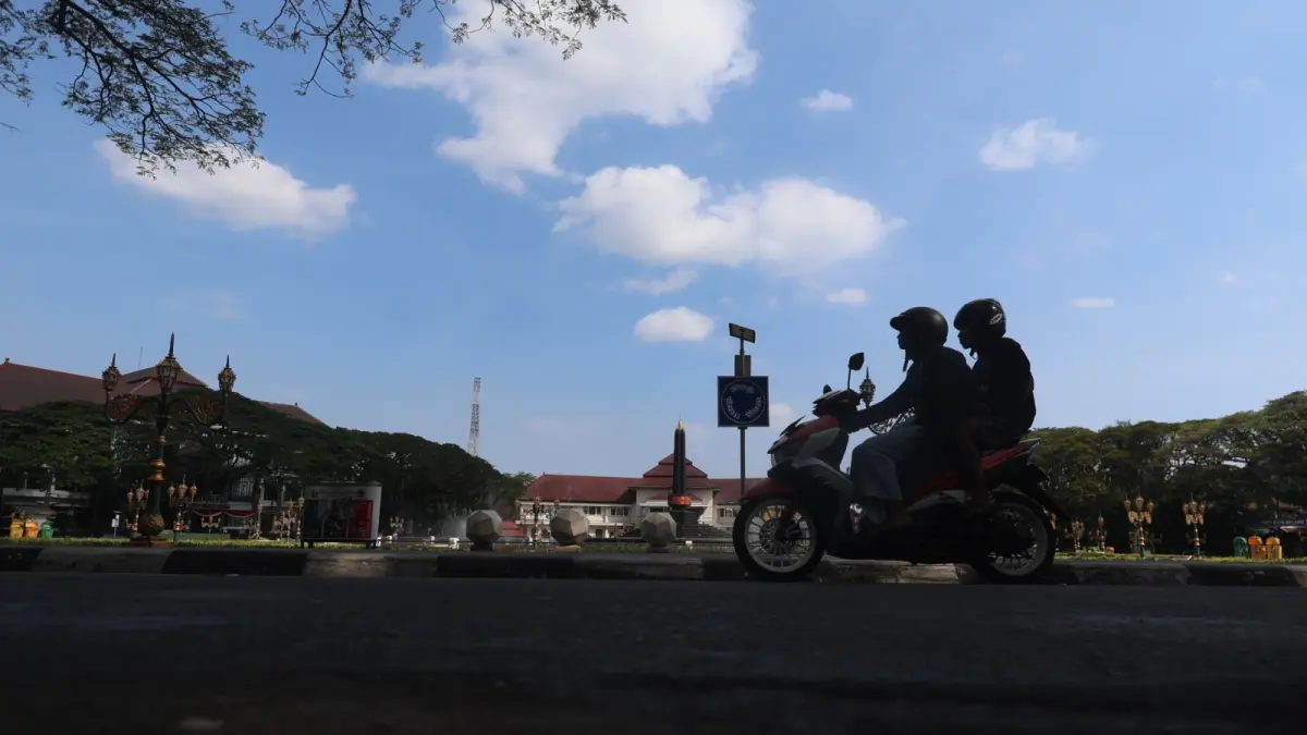 HARUS WASPADA: Seorang pengendara sepeda motor melintasi Bundaran Tugu Malang, kemarin. Warga  yang beraktivitas di luar ruangan disarankan menggunakan alat pelindung pada musim kemarau. (foto: Darmono)