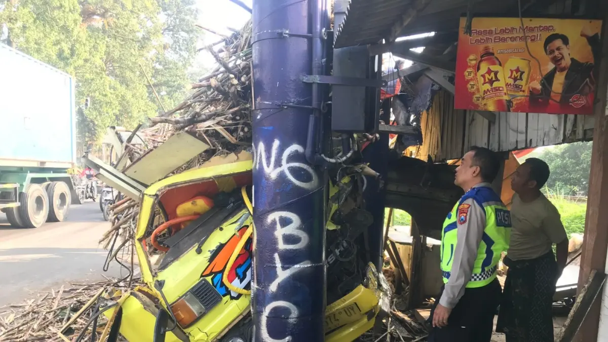 Truk bermuatan tebu baru berhenti setelah menghantam tiang penyangga reklame di Lawang, Malang.